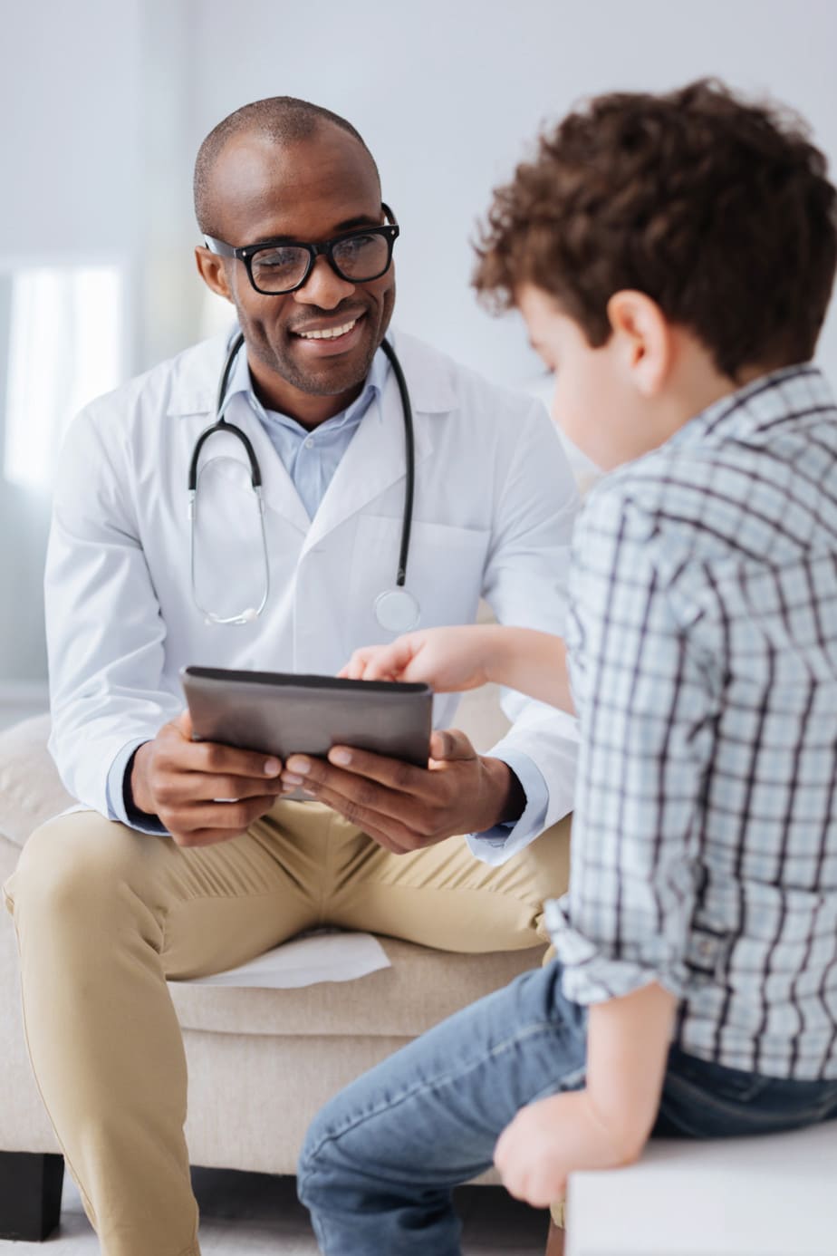 smiling-doctor-talking-to-child-patient